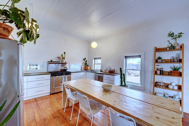 kitchen with pendant lighting, white cabinetry, light hardwood / wood-style flooring, and stainless steel appliances