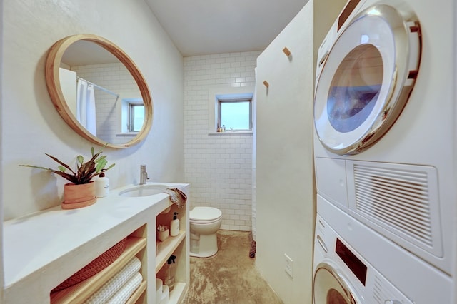 bathroom featuring toilet, vanity, and stacked washer and dryer