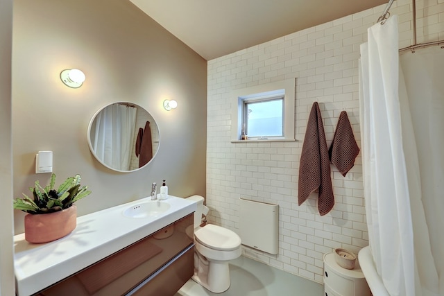 bathroom with toilet, vanity, and tile walls