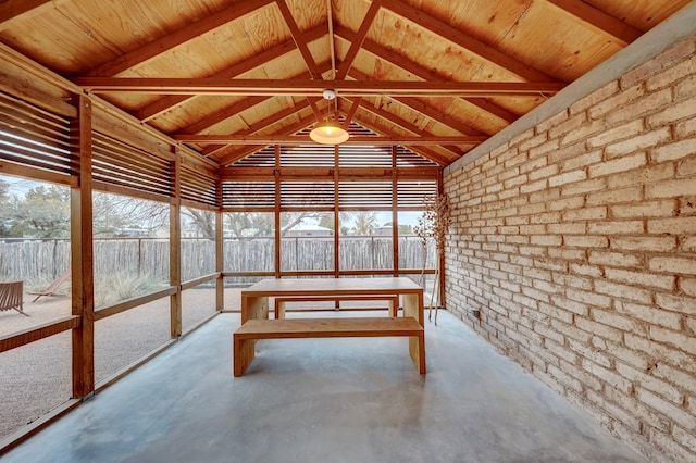 unfurnished sunroom with vaulted ceiling with beams