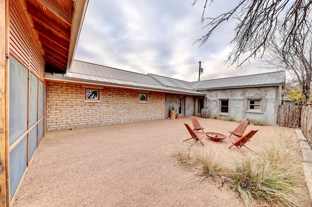 back of property featuring a patio and a fire pit