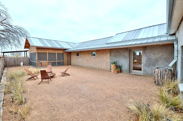 rear view of property featuring a sunroom and a patio