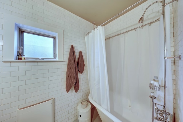 bathroom featuring tile walls and shower / tub combo with curtain