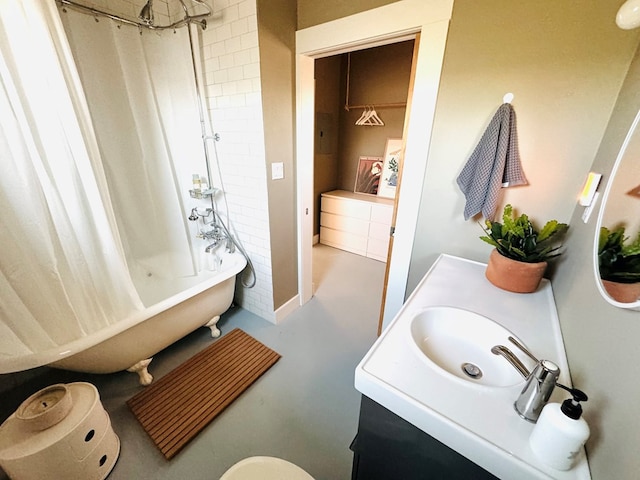 full bathroom featuring concrete floors, toilet, vanity, and shower / bath combo with shower curtain