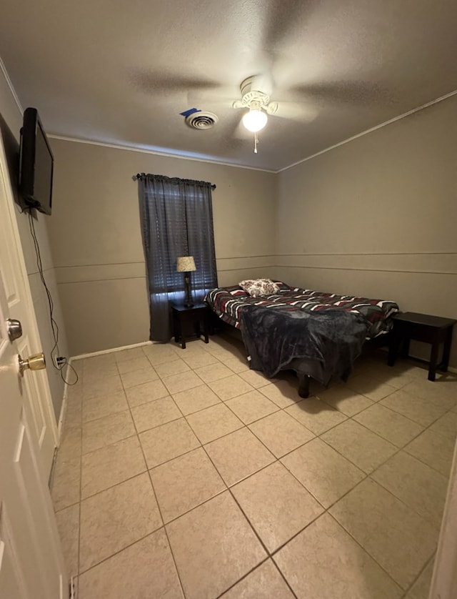 unfurnished bedroom featuring ceiling fan, light tile patterned floors, and ornamental molding