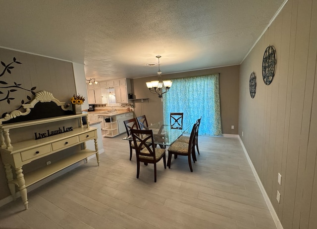 dining area featuring wooden walls, a notable chandelier, and light wood-type flooring