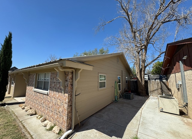 view of side of home featuring a patio and central AC unit