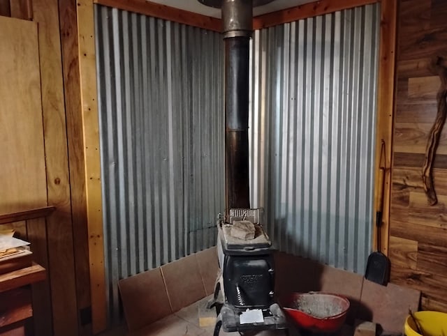 miscellaneous room with tile patterned floors and a wood stove