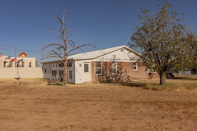 rear view of property featuring a lawn