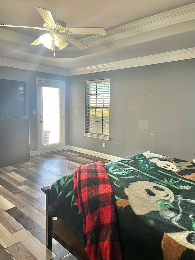 bedroom featuring a raised ceiling, ceiling fan, hardwood / wood-style floors, and crown molding