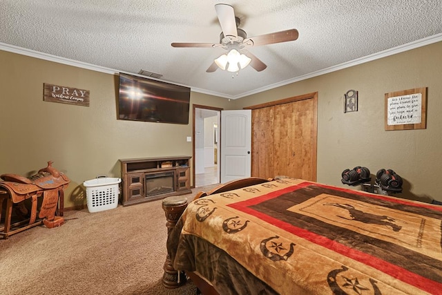 bedroom featuring carpet, ceiling fan, ornamental molding, a textured ceiling, and a closet