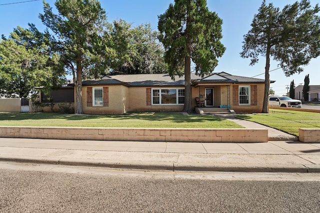 ranch-style home featuring a front lawn