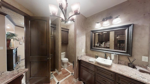 bathroom with vanity, a chandelier, and toilet