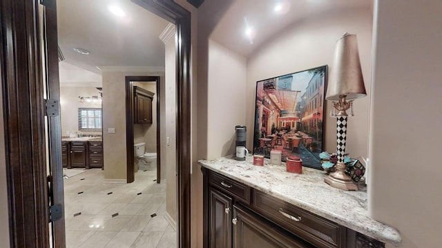 corridor featuring ornamental molding and light tile patterned floors