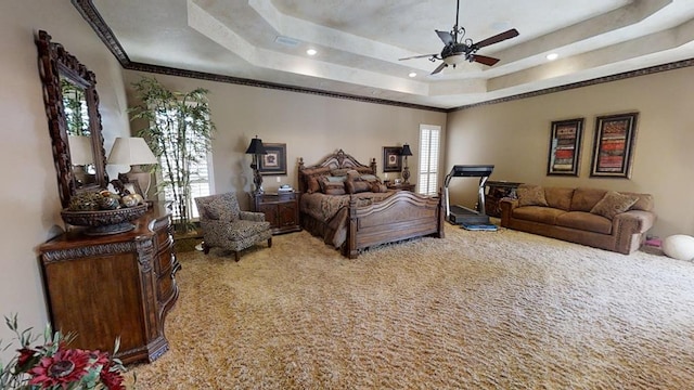 carpeted bedroom with ceiling fan, ornamental molding, and a tray ceiling