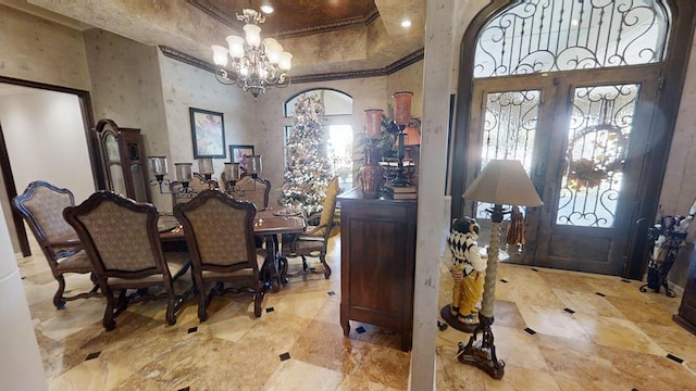 foyer entrance featuring french doors, a high ceiling, and a chandelier