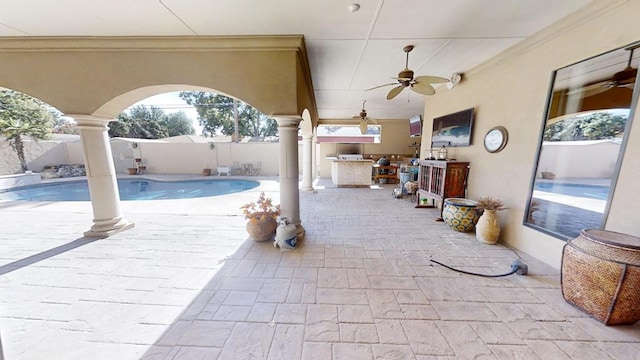 view of patio / terrace featuring a fenced in pool, ceiling fan, and exterior kitchen