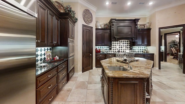 kitchen with light stone countertops, appliances with stainless steel finishes, dark brown cabinetry, and a kitchen island