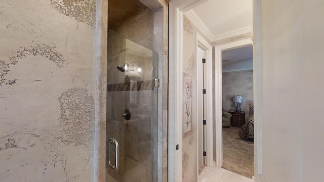 bathroom featuring a shower with door and crown molding