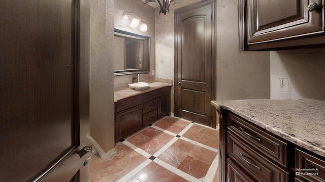 bathroom featuring a notable chandelier, vanity, and tile patterned floors