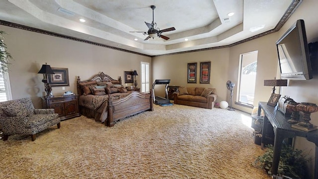 bedroom with carpet, a tray ceiling, and ceiling fan