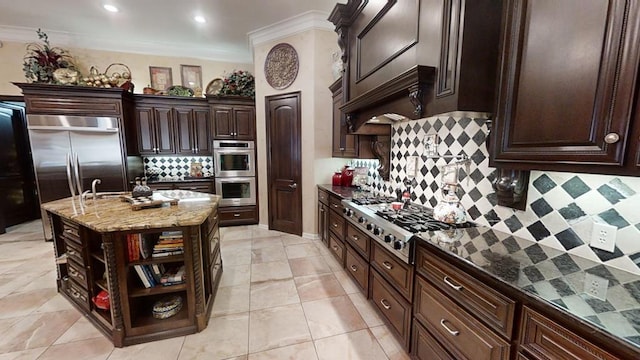 kitchen featuring a center island, backsplash, dark stone countertops, dark brown cabinetry, and stainless steel appliances