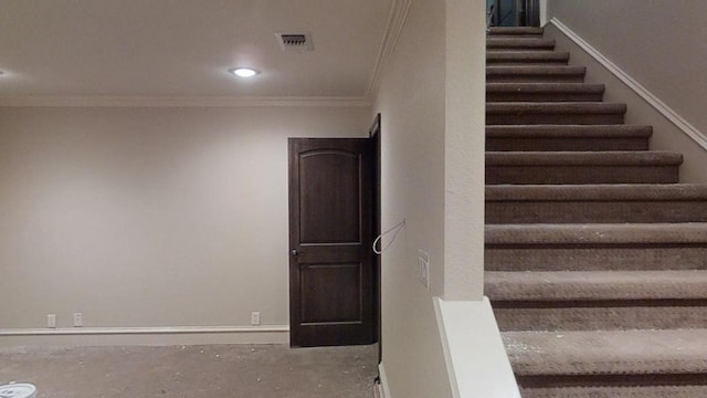 stairs featuring concrete floors and ornamental molding