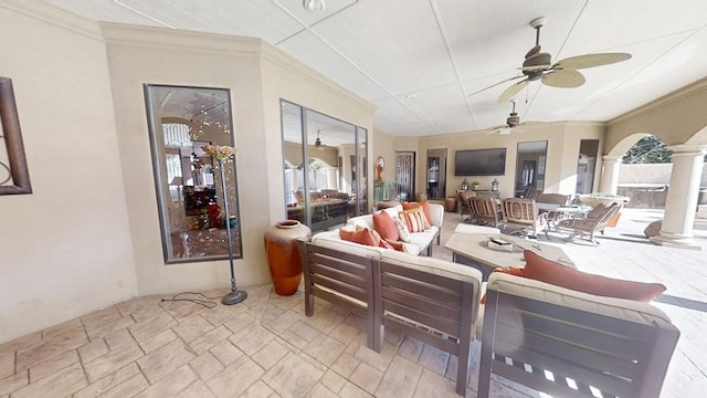 sunroom featuring decorative columns, ceiling fan, and a healthy amount of sunlight