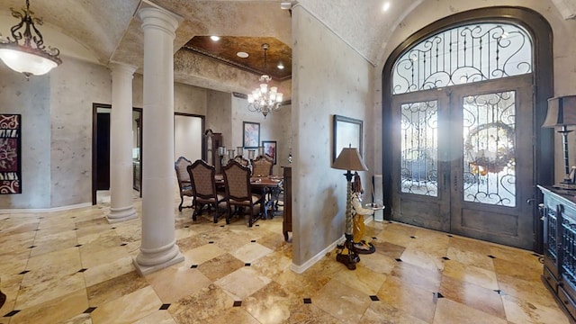 entryway featuring an inviting chandelier, decorative columns, and french doors