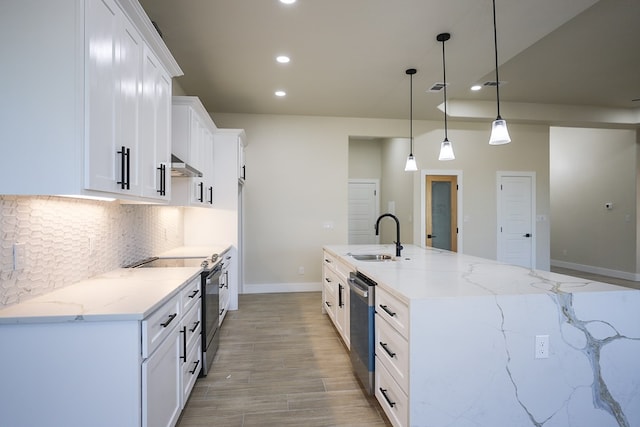 kitchen with white cabinetry, sink, light stone counters, pendant lighting, and appliances with stainless steel finishes