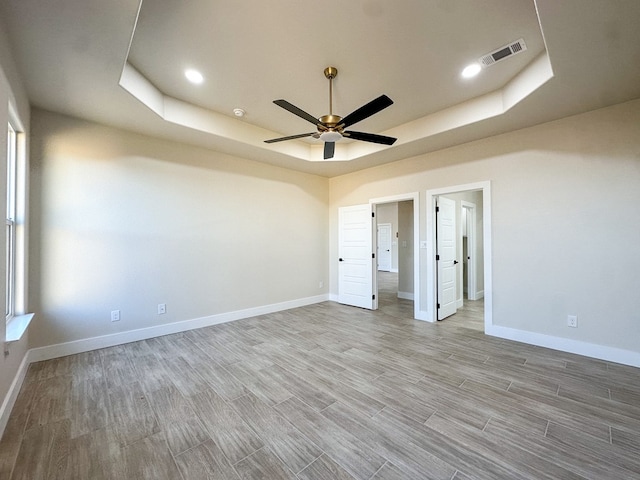 unfurnished bedroom with a raised ceiling and ceiling fan