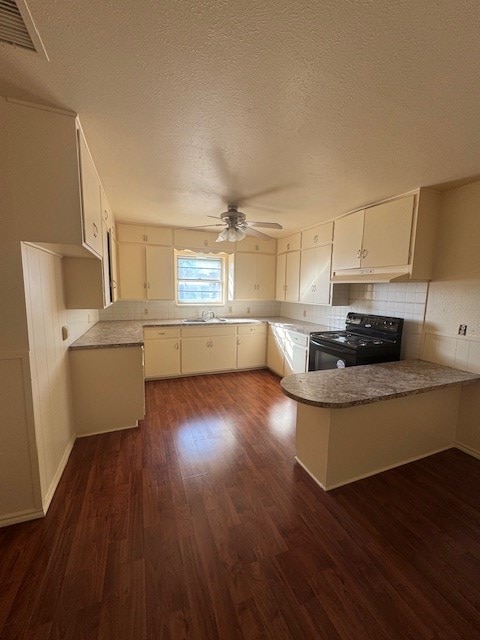 kitchen featuring dark wood-style floors, ceiling fan, a peninsula, black electric range, and under cabinet range hood