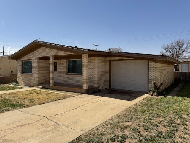 ranch-style house featuring a garage, driveway, and brick siding