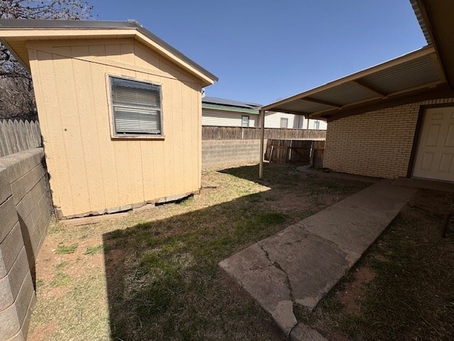 exterior space featuring an outbuilding, a fenced backyard, and a storage shed