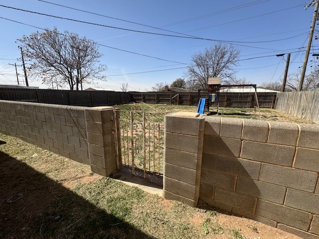 view of yard with a playground and a fenced backyard