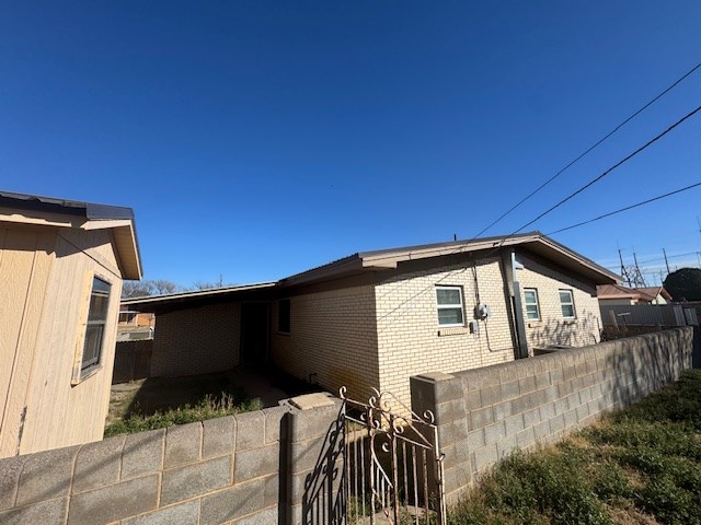 view of property exterior with fence and brick siding