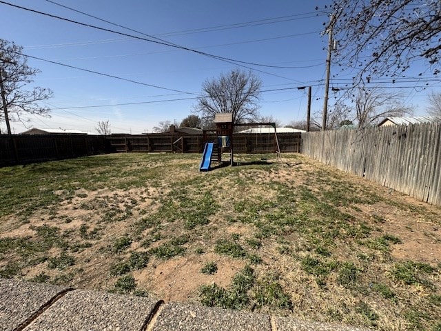 view of yard featuring a fenced backyard and a playground