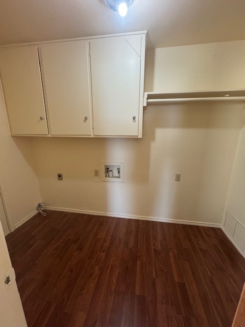 laundry area featuring cabinet space, baseboards, dark wood-style floors, washer hookup, and electric dryer hookup