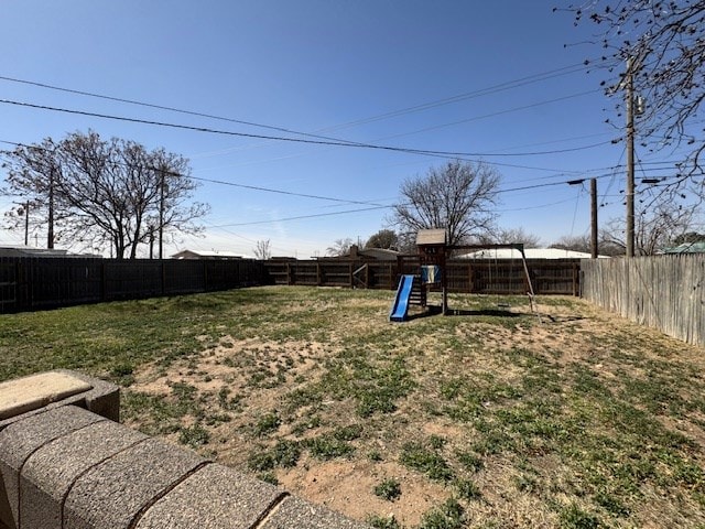 view of yard with a playground and a fenced backyard