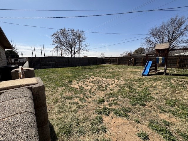 view of yard featuring a fenced backyard and a playground