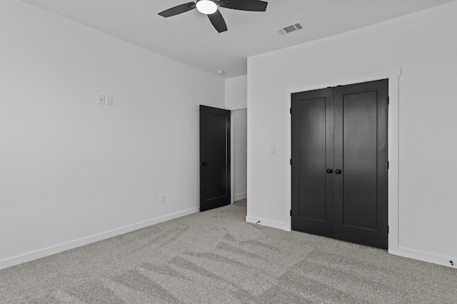 unfurnished bedroom featuring light colored carpet, a closet, and ceiling fan