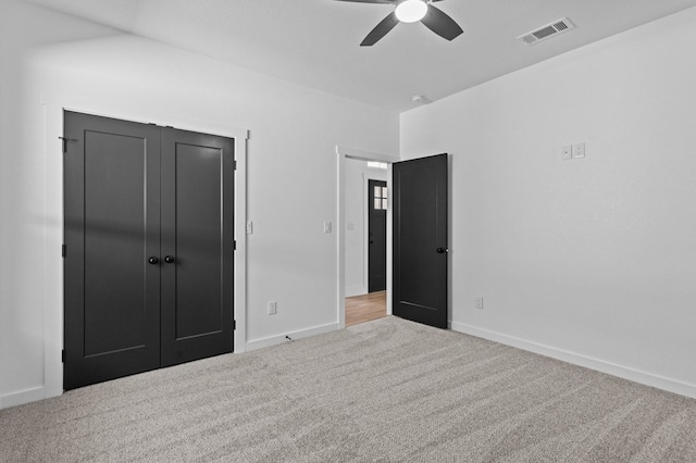 unfurnished bedroom with light carpet, ceiling fan, and a closet