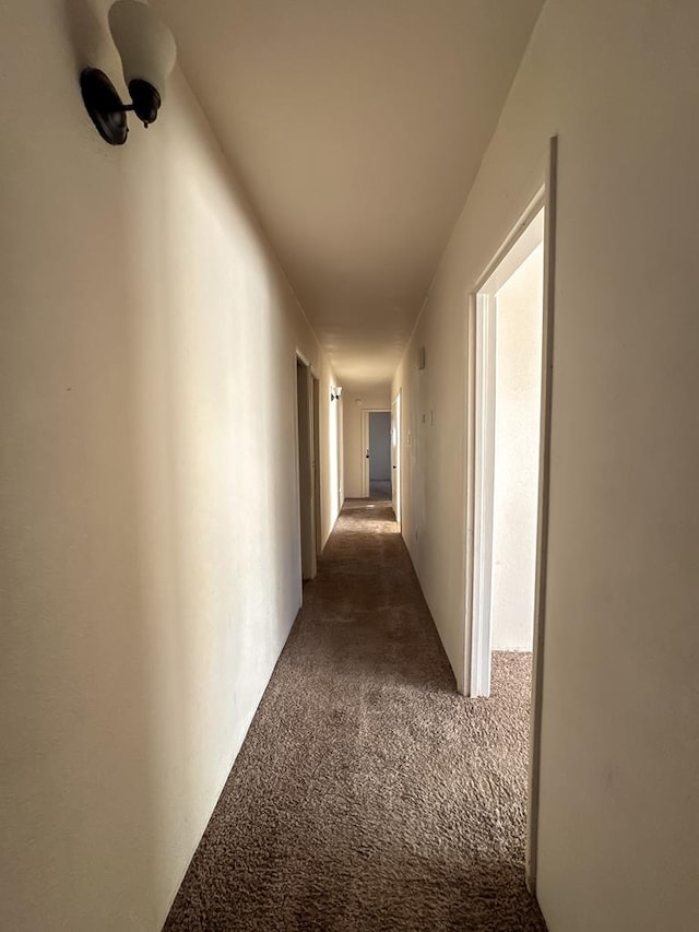 hall with dark colored carpet