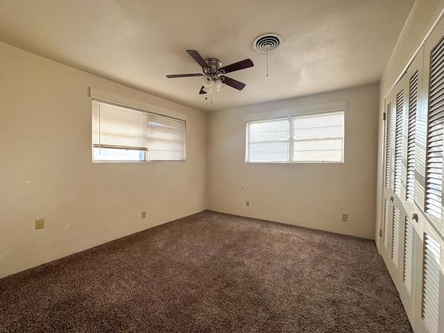 unfurnished bedroom featuring dark carpet and ceiling fan