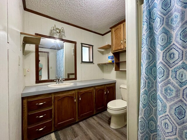 bathroom featuring toilet, vanity, ornamental molding, and hardwood / wood-style flooring