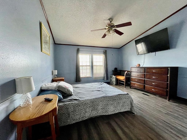 bedroom with ceiling fan, vaulted ceiling, a textured ceiling, hardwood / wood-style flooring, and ornamental molding