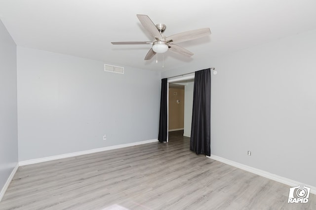 empty room with light wood-style flooring, visible vents, ceiling fan, and baseboards