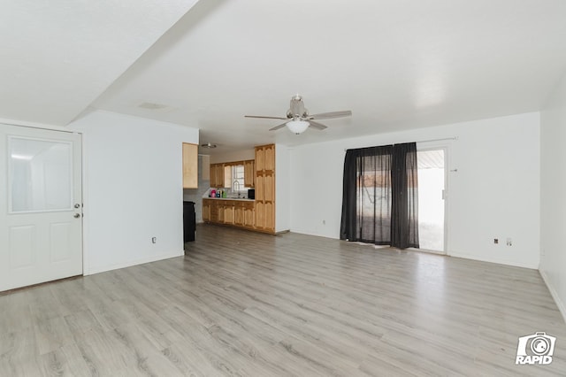 unfurnished living room with a ceiling fan, light wood-type flooring, and baseboards