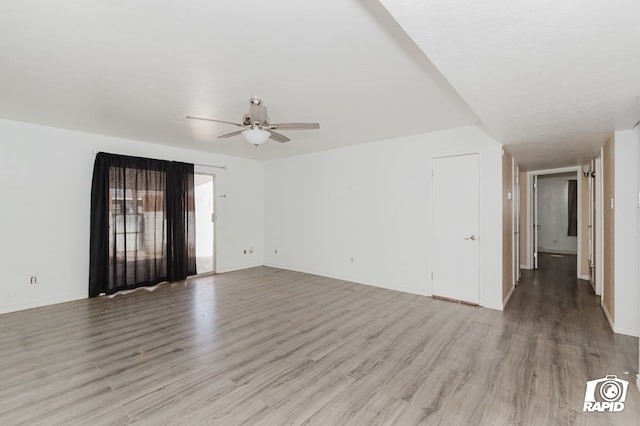 unfurnished room with a ceiling fan, light wood-style flooring, and baseboards