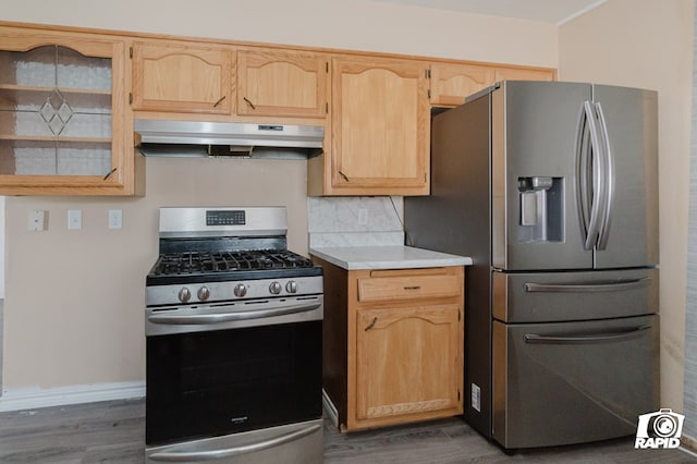 kitchen with light brown cabinets, under cabinet range hood, stainless steel appliances, dark wood-style flooring, and light countertops